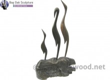 Family of herons in bog oak by Michael Casey